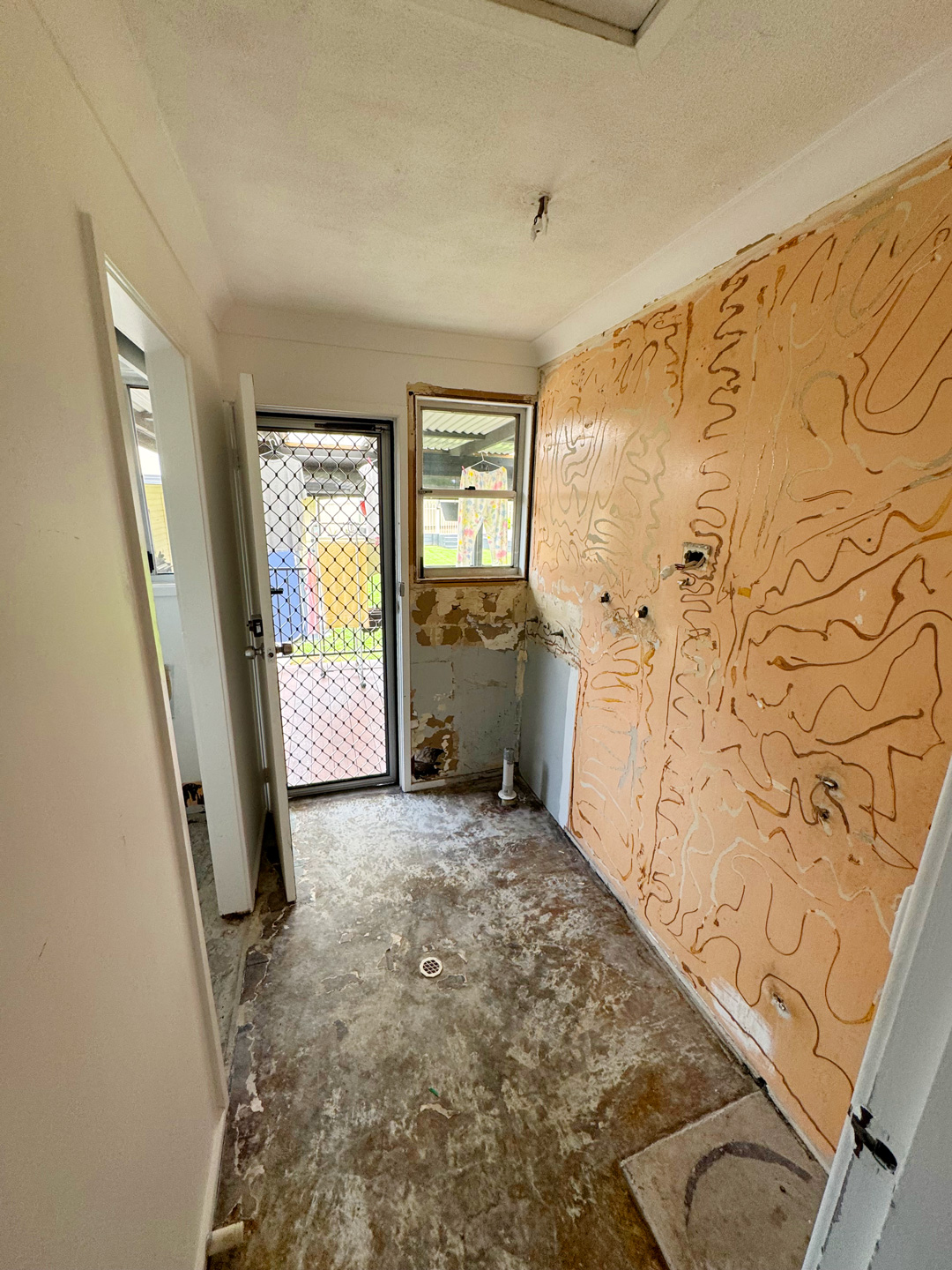 A room undergoing construction, likely a laundry or utility area.